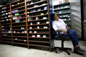 A pharmacy employee waits for customers at a drugstore in Caracas. (Noel West / Reuters)